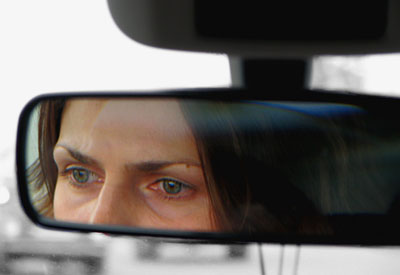 Водитель смотрит в зеркало. Глаза в зеркале машины.